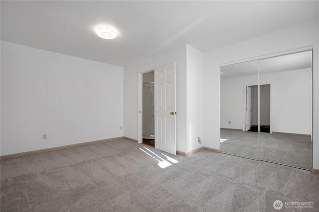 unfurnished bedroom featuring light carpet, a closet, and baseboards