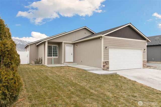 ranch-style home featuring an attached garage, fence, concrete driveway, stone siding, and a front yard