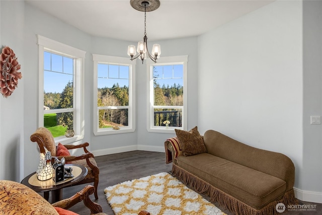 living area featuring a chandelier, dark wood-style flooring, a wealth of natural light, and baseboards