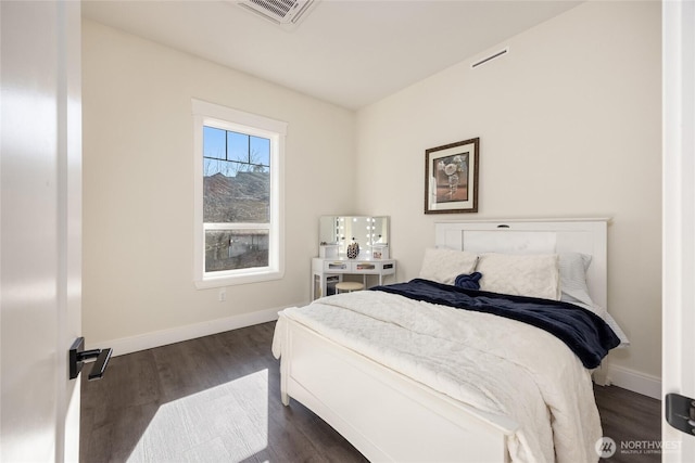 bedroom with dark wood-style flooring, visible vents, and baseboards