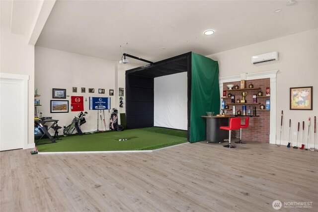 recreation room featuring golf simulator, a wall mounted AC, wood finished floors, and recessed lighting