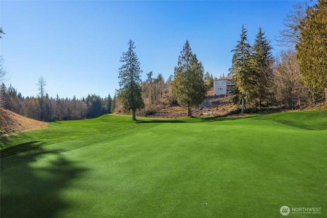 surrounding community featuring view of golf course and a lawn