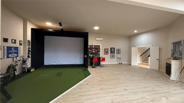 rec room featuring baseboards, light wood-style flooring, a fireplace, golf simulator, and recessed lighting