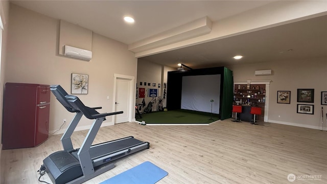 exercise area with golf simulator, recessed lighting, a wall mounted AC, wood finished floors, and baseboards