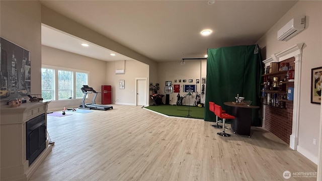 workout area featuring baseboards, a wall unit AC, light wood-style floors, golf simulator, and recessed lighting