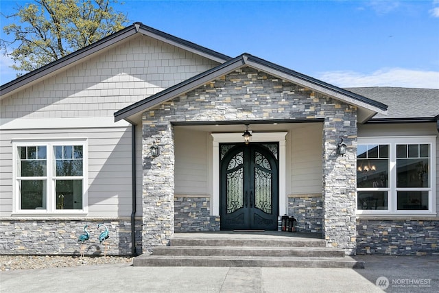 doorway to property featuring stone siding and french doors
