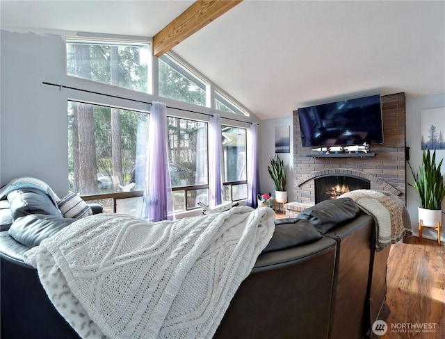 living room featuring vaulted ceiling with beams, a fireplace, and wood finished floors