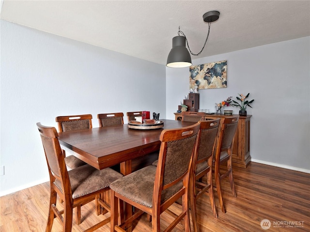 dining area featuring wood finished floors and baseboards