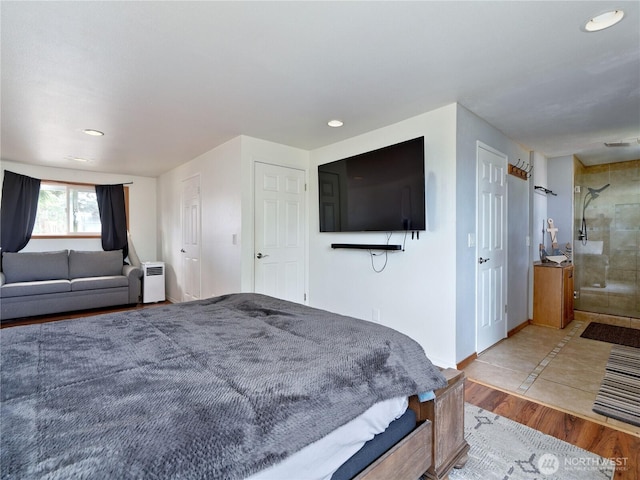 bedroom with baseboards, wood finished floors, visible vents, and recessed lighting