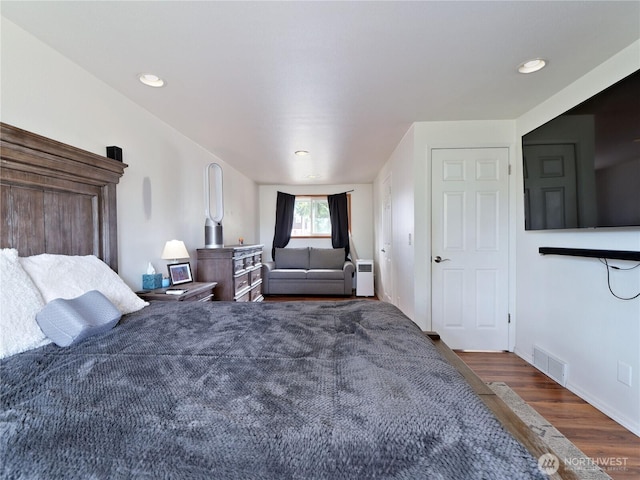 bedroom featuring baseboards, visible vents, wood finished floors, and recessed lighting