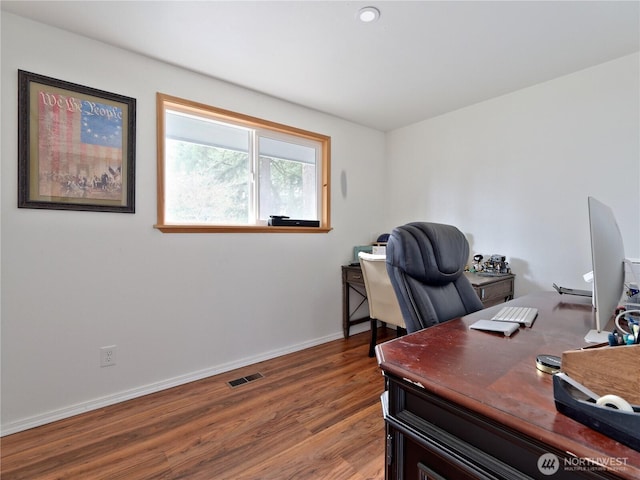 office with baseboards, visible vents, and wood finished floors