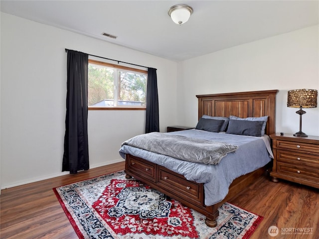 bedroom featuring dark wood-type flooring, visible vents, and baseboards