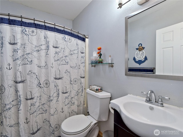 bathroom with curtained shower, vanity, and toilet