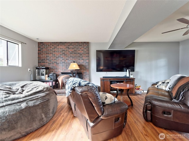 living room with wood finished floors, a ceiling fan, and baseboards