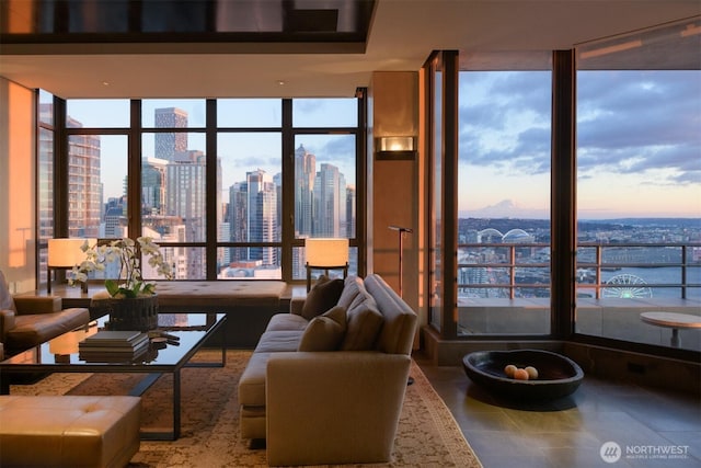 tiled living room with a view of city, a wall of windows, a water view, and a wealth of natural light