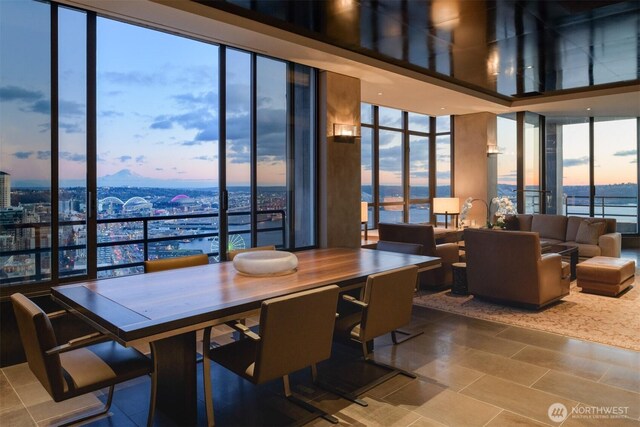 dining room featuring expansive windows, tile patterned flooring, and a water view