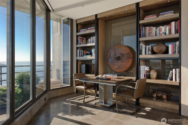 sitting room with a water view and tile patterned flooring