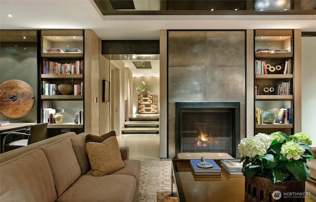 living area with a warm lit fireplace and wood finished floors