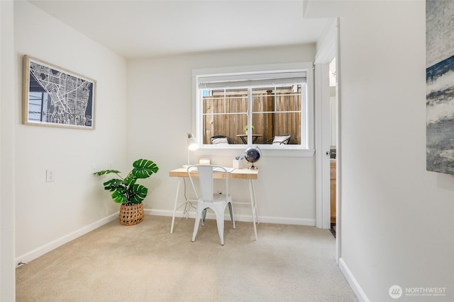 office area featuring baseboards and light colored carpet