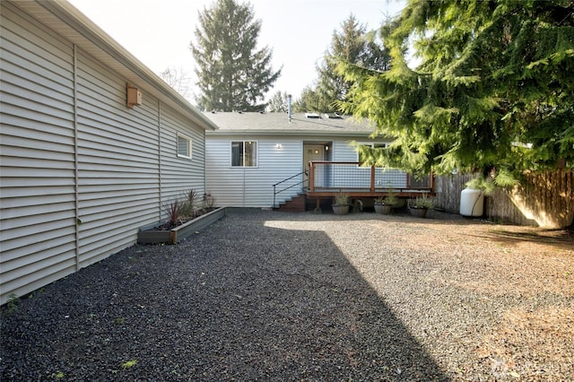 back of house with fence and a wooden deck