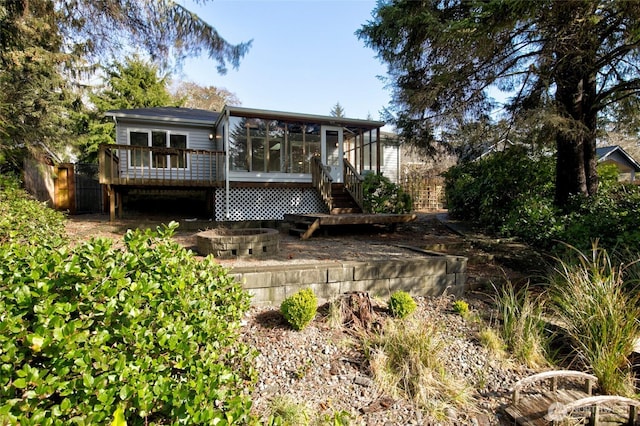 rear view of property featuring a sunroom, fence, and a deck