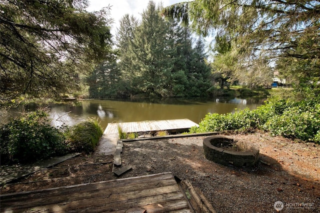 view of dock featuring an outdoor fire pit and a water view