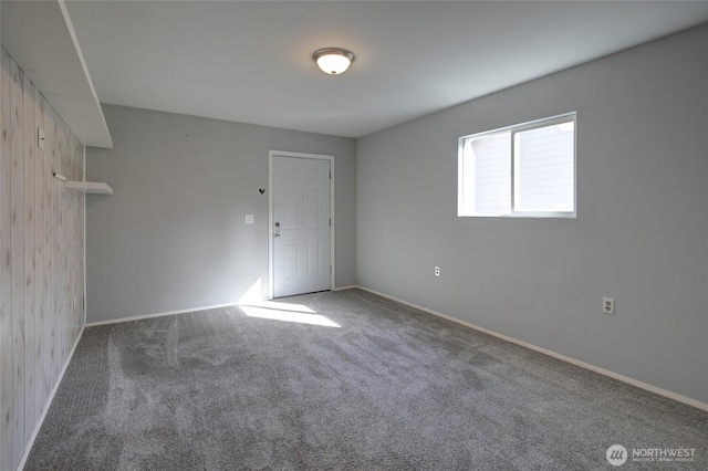 carpeted spare room featuring baseboards