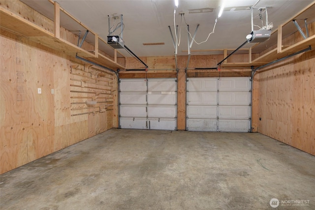 garage with wood walls and a garage door opener