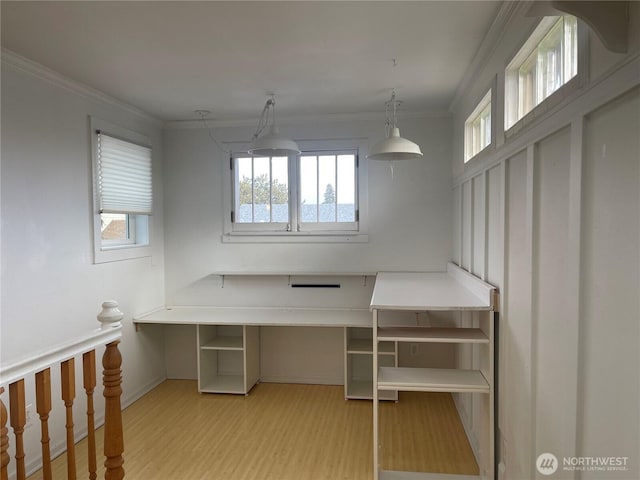 interior space with light wood-style floors, crown molding, and baseboards