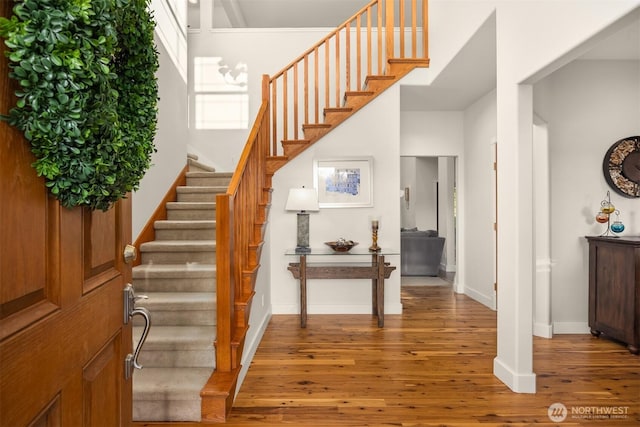 entryway with stairway, baseboards, and wood finished floors