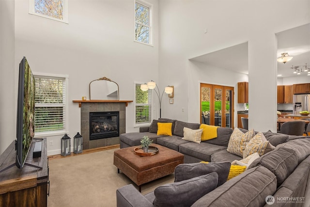 living area with a high ceiling, a fireplace, and baseboards