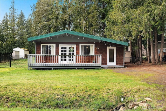 view of front of home featuring a wooden deck, a front lawn, and fence