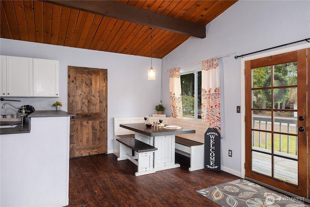 dining room with dark wood-type flooring, a healthy amount of sunlight, and vaulted ceiling with beams