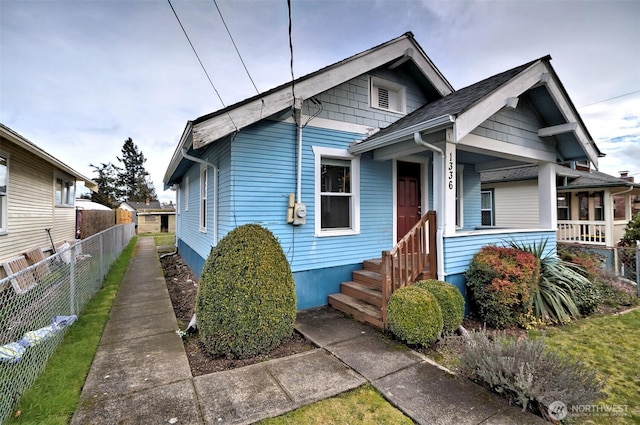 bungalow-style home with fence