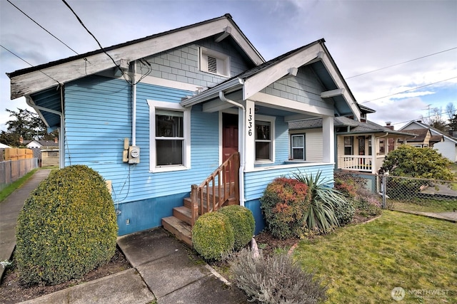 bungalow-style home with fence and a front yard