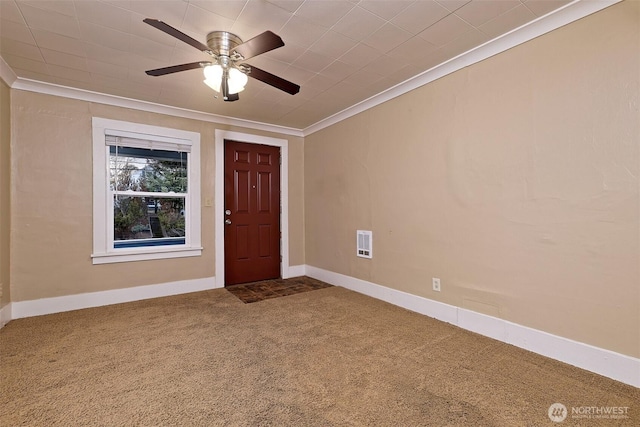 carpeted foyer featuring a ceiling fan, baseboards, visible vents, and crown molding