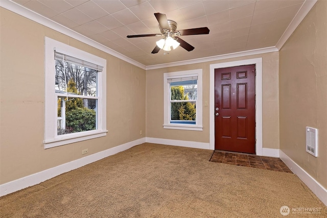 carpeted foyer entrance featuring baseboards, visible vents, a ceiling fan, and ornamental molding