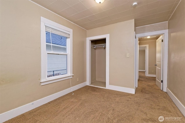 unfurnished bedroom featuring carpet, a closet, and baseboards