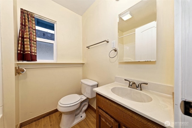 bathroom with toilet, vanity, wood finished floors, baseboards, and walk in shower