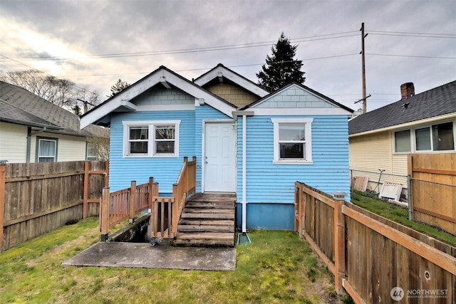 back of property with a yard and a fenced backyard