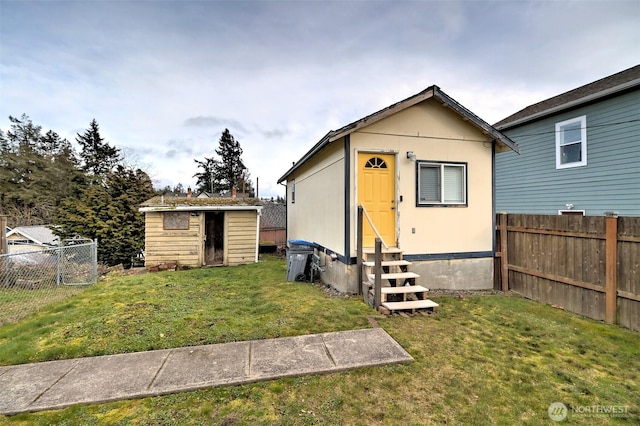 view of outdoor structure featuring entry steps, an outbuilding, and fence