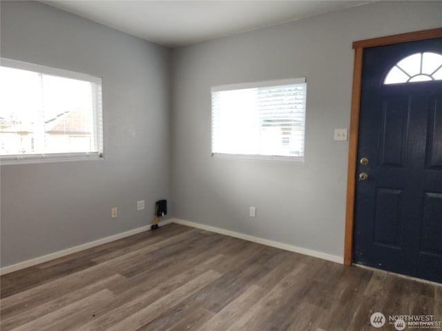 foyer featuring baseboards and wood finished floors