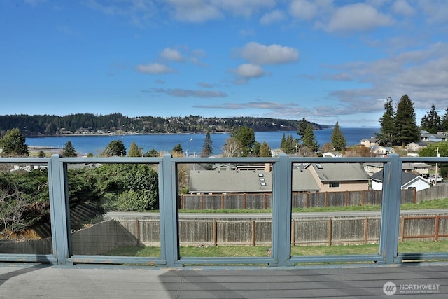 view of gate with fence and a water view