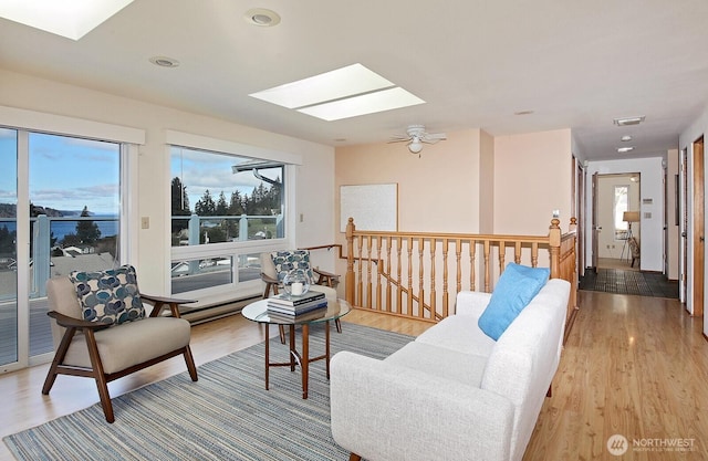 living area with a skylight, light wood-style floors, and a wealth of natural light