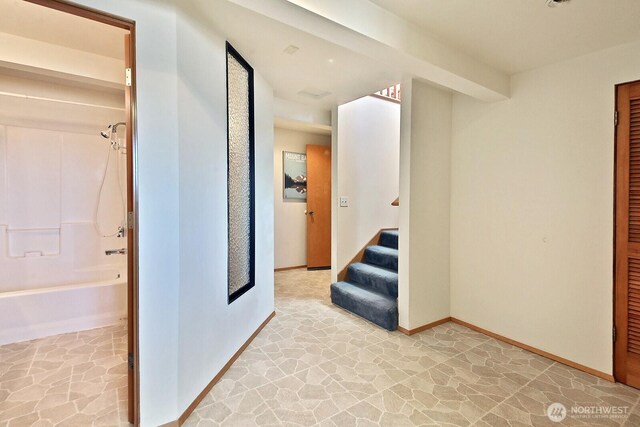 hall with stairway, baseboards, and stone floors