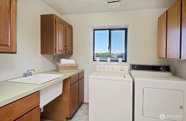 laundry area featuring washer and dryer, cabinet space, visible vents, and a sink