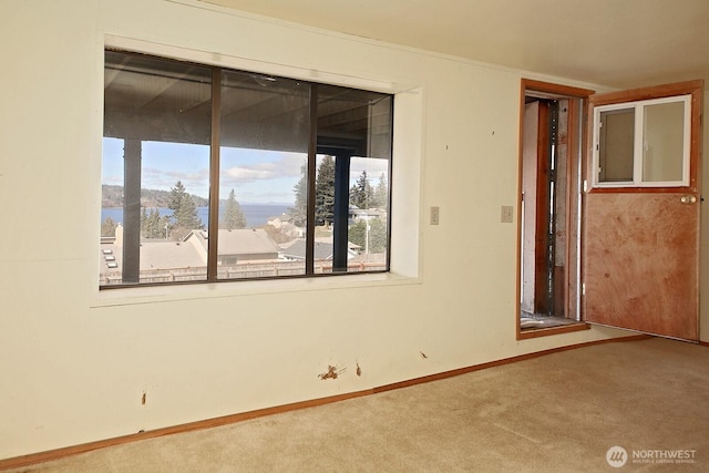 unfurnished room with carpet flooring and baseboards