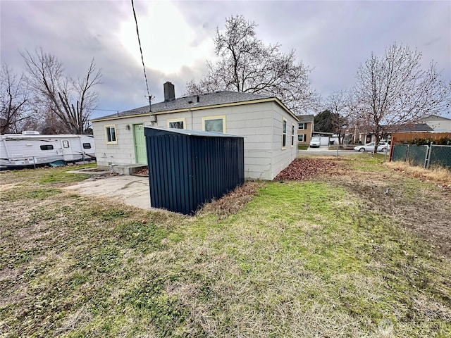 back of house featuring fence and a lawn