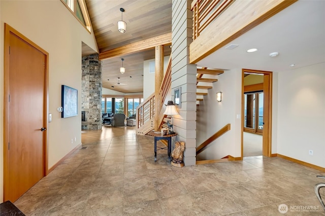 entrance foyer with high vaulted ceiling, wooden ceiling, stairway, and baseboards