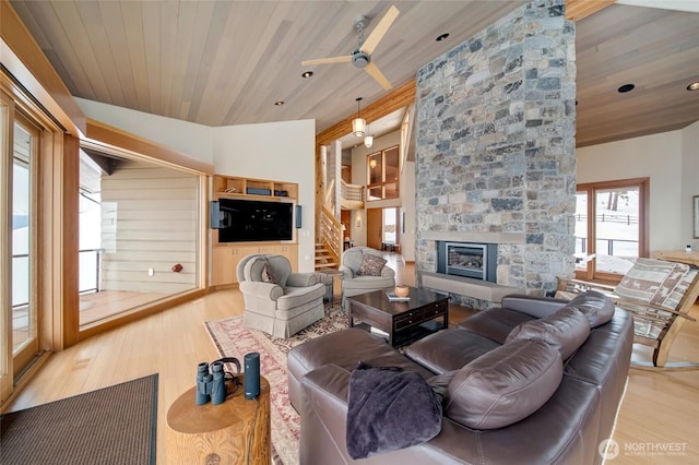 living area featuring wood ceiling, a fireplace, wood finished floors, and stairs